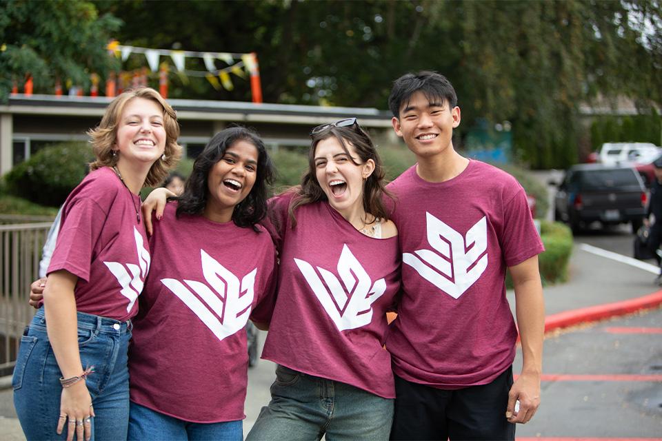 Four SPU student leaders smile broadly over an Orientation weekend